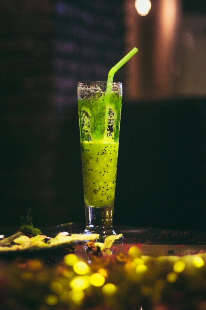 Inviting kiwi smoothie with straw in a tall glass. Perfect refreshment.